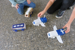 Kinder spielen mit selbst gebauten Fahrzeugen