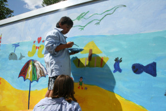 Kinder bemalen Garagenwand mit eigenen Motiven 