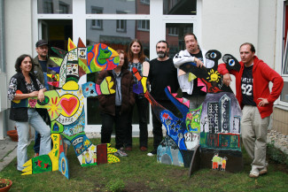 Gruppe mit Figuren "Feuerdrache" und "Raffzahn" vor DGB-Haus