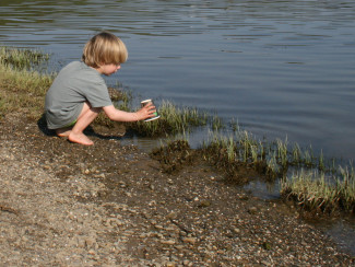 Junge entdeckt Wasser am Bach