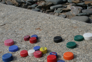 alte Plastikdeckel, gesammelt am Strand, Cornwall