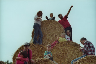 Kinder und Erzieherinnen auf Heuballen