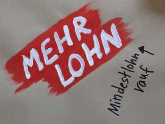 Mehr Lohn - Schriftzug auf Wandzeitung