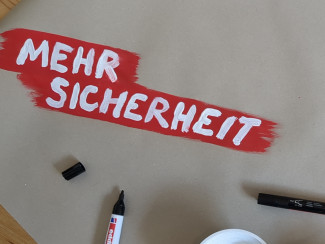 Mehr Sicherheit - Schriftzug auf Wandzeitung