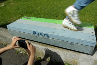 Ein Kind fotografiert eine Bank bei Stadtteilbegehung