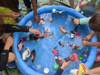 Kinder experimentieren am Planschbecken