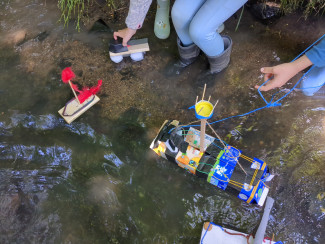 Kinder lassen Boote schwimmen