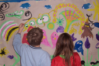 Kinder malen an Wandtapete
